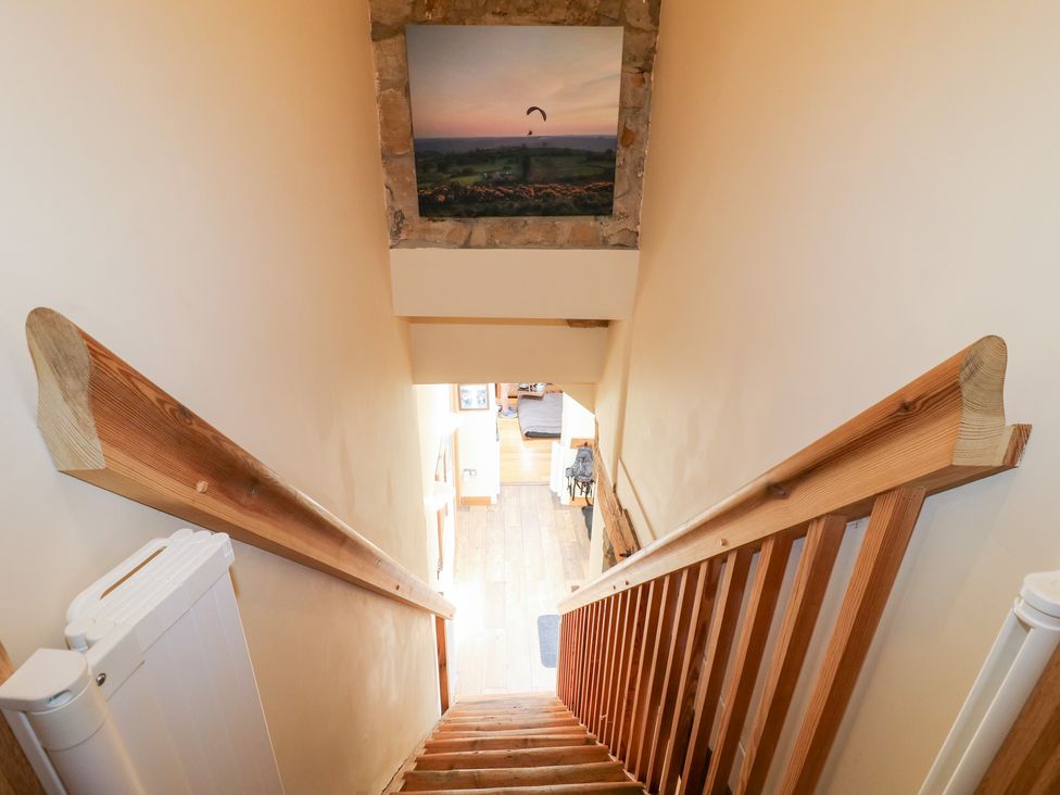 A staircase with wooden handrail and painting at 33 Main Road, Higham Derbyshire