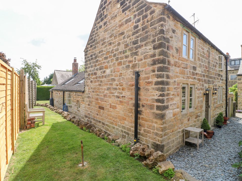 A garden with a house and seating area at 33 Main Road in Higham Derbyshire