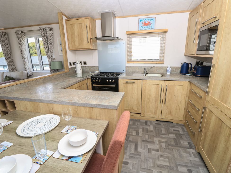 A kitchen with stove and dining area at 31 Crosswinds in Bembridge
