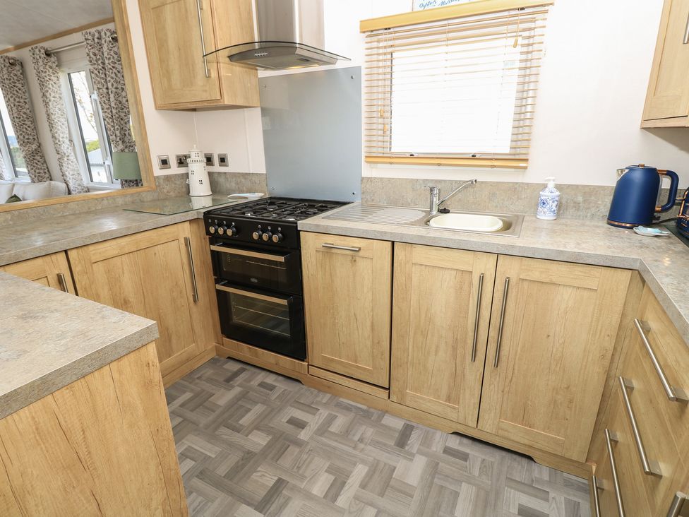 A kitchen with cabinets, stove, oven, and sink at 31 Crosswinds in Bembridge