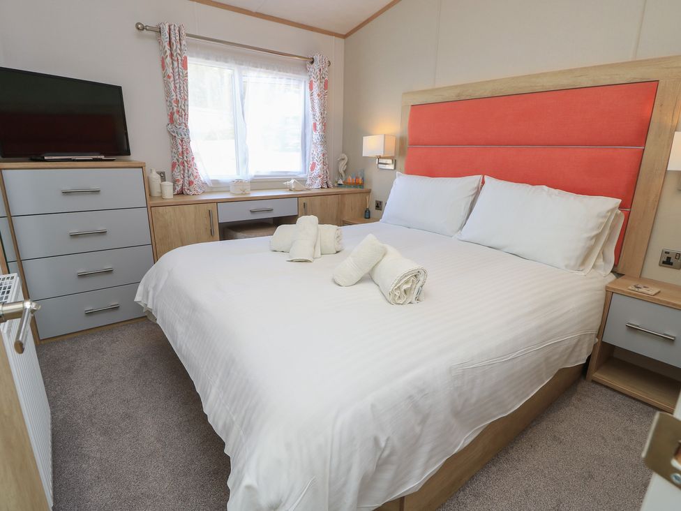 A bedroom with a bed and television at 31 Crosswinds in Bembridge