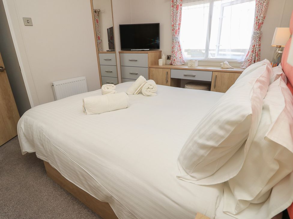 A bedroom with a bed and tv at 31 Crosswinds in Bembridge