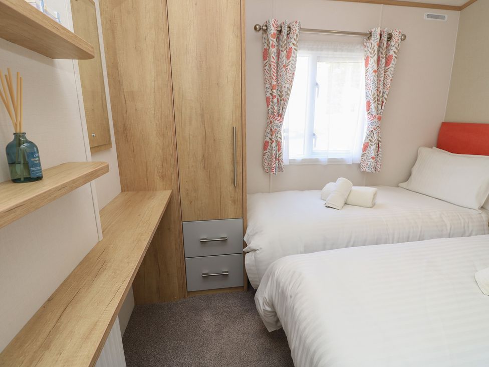 A bedroom with two beds and a wardrobe at 31 Crosswinds Bembridge