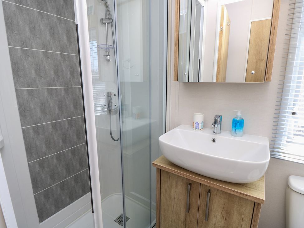 A bathroom with a shower and a wash basin at 31 Crosswinds in Bembridge