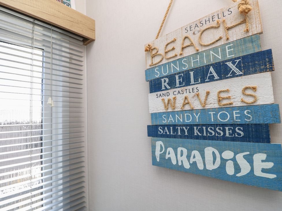 A wall with blinds and decorative sign at 31 Crosswinds Bembridge