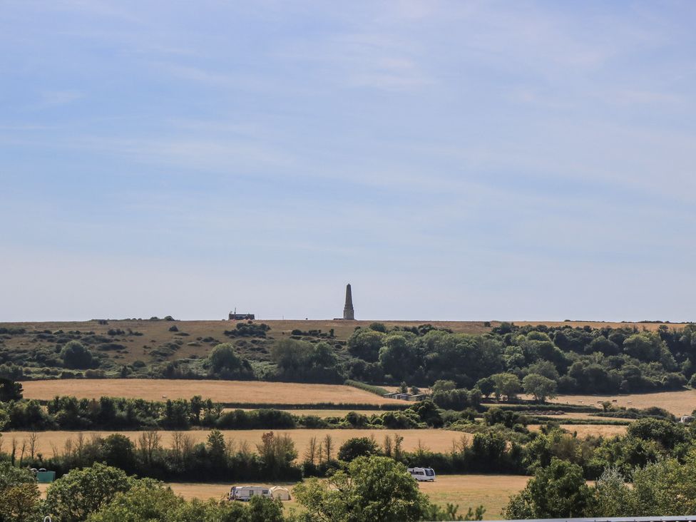 A view of a hill with a monument and trees at 31 Crosswinds in Bembridge