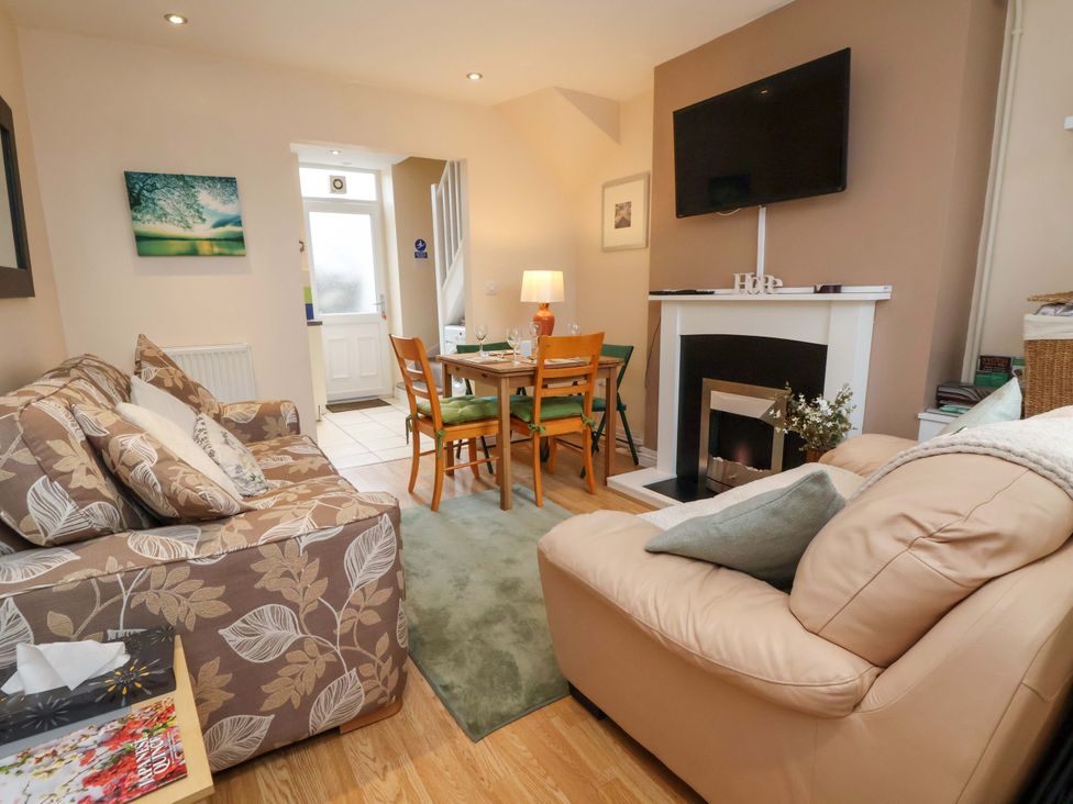 A living room with a sofa and dining table at Hill View in Bala