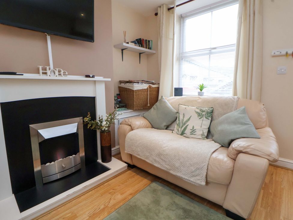 A living room with a sofa and a fireplace at Hill View in Bala