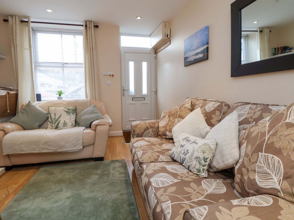 A living room with two sofas and a door at Hill View in Bala