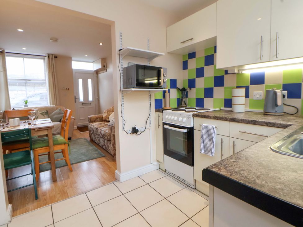 A kitchen with a dining area and sofa at Hill View in Bala