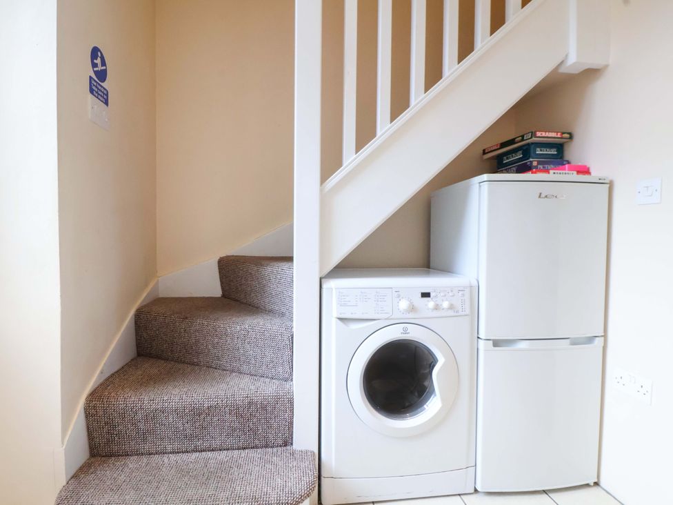 A utility room with a washing machine and fridge at Hill View in Bala