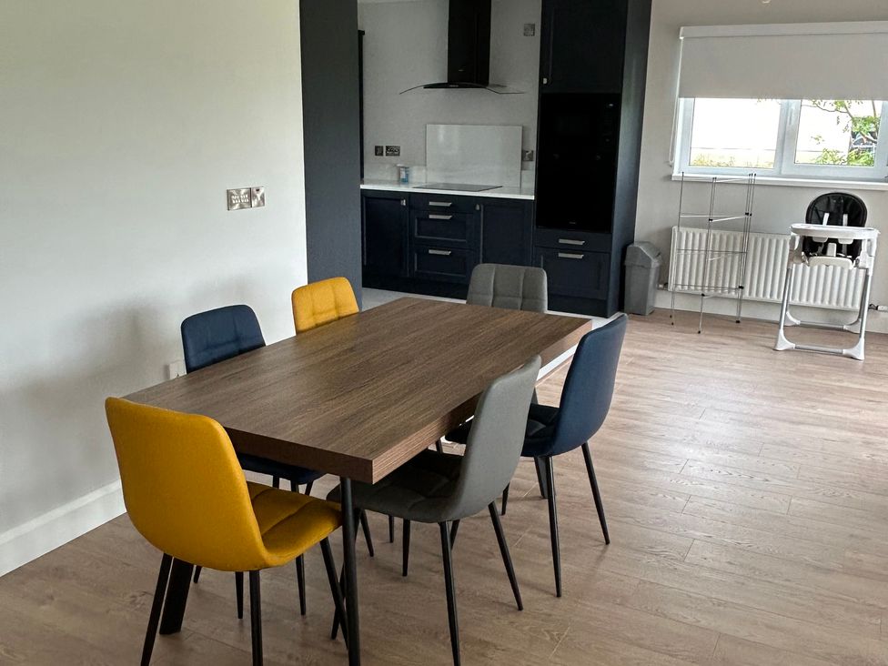 A dining room with a table and chairs at 30 River Run in Belturbet