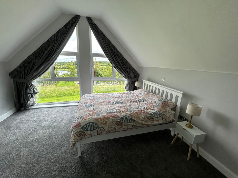 A bedroom with a bed and window view at 30 River Run in Belturbet
