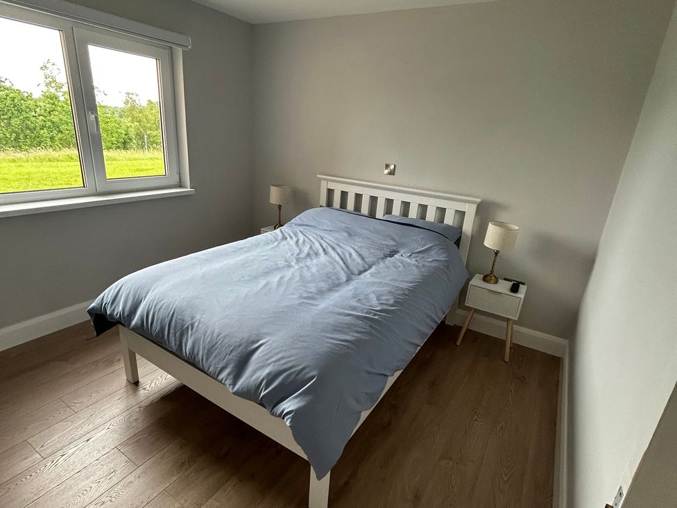 A bedroom with a bed and a nightstand at 30 River Run in Belturbet