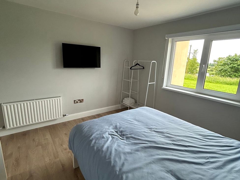 A bedroom with a bed and a television at 30 River Run in Belturbet
