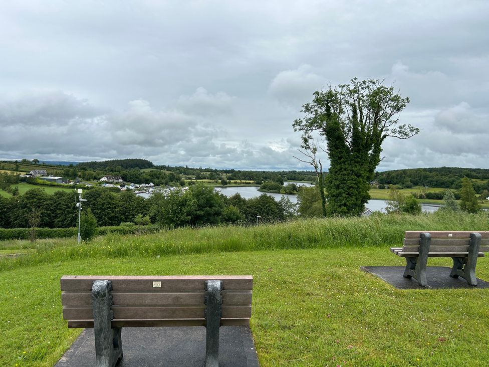 A view of a lake and benches at 30 River Run in Belturbet