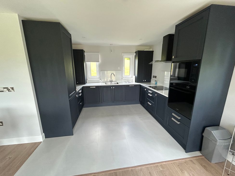 A kitchen with cabinets and appliances at 30 River Run in Belturbet, County Cavan