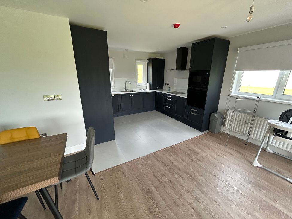 A kitchen with cabinets, sink, stove, and table at 30 River Run, Belturbet, County Cavan