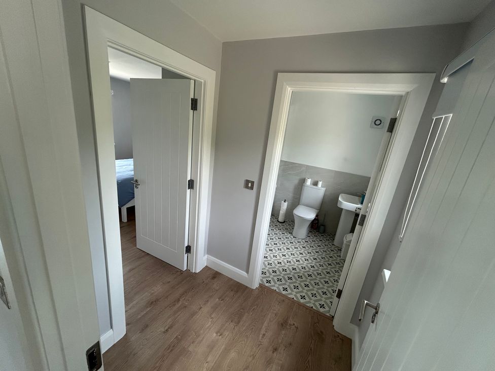 A hallway with doors to a bedroom and a bathroom at 30 River Run, Belturbet, County Cavan