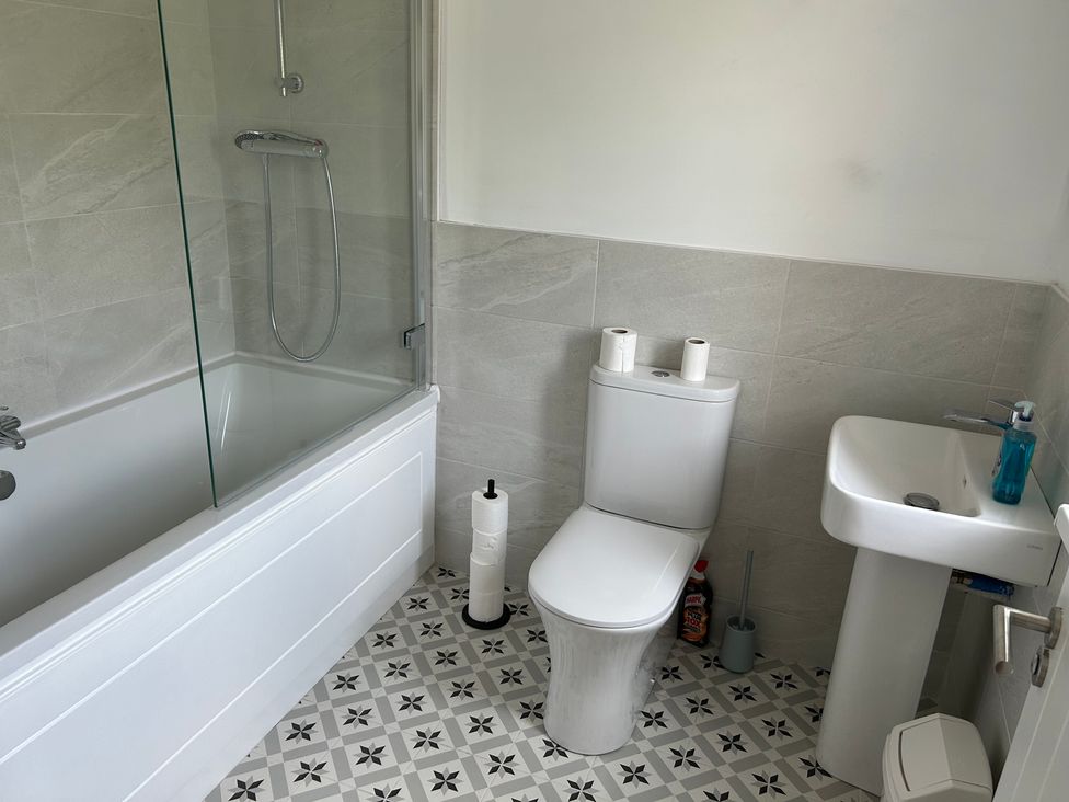 A bathroom with a bathtub, toilet, and sink at 30 River Run, Belturbet, County Cavan