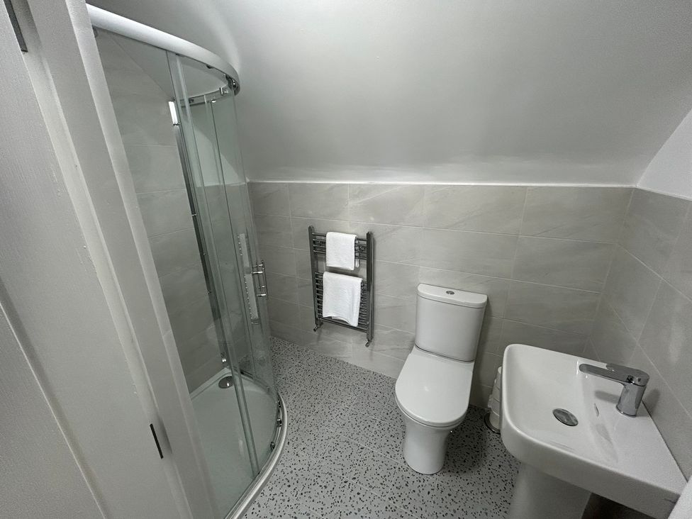 A bathroom with shower, toilet, and sink at 30 River Run, Belturbet, County Cavan
