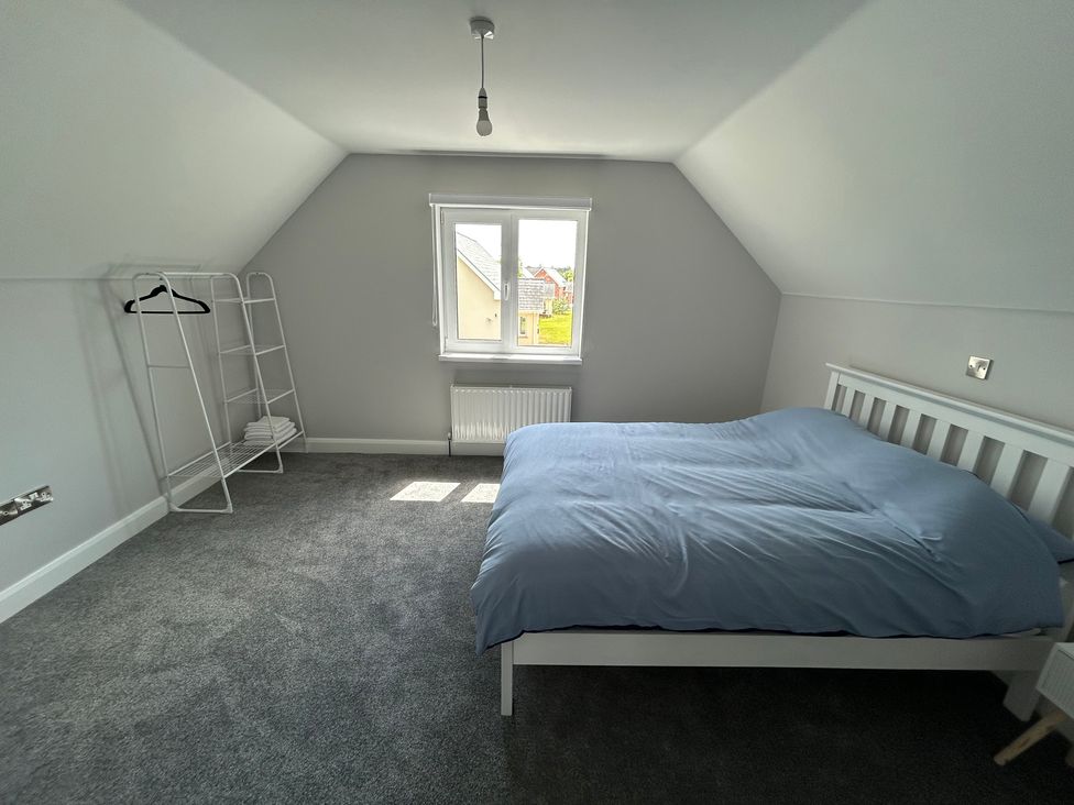 A bedroom with a bed and a clothing rack at 30 River Run, Belturbet, County Cavan