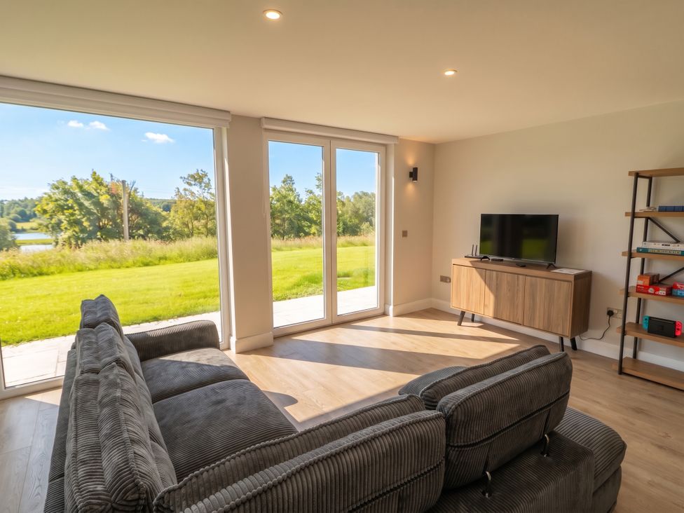 A living room with a sofa and TV stand at 30 River Run, Belturbet, County Cavan