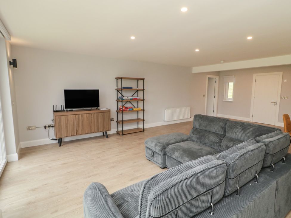 A living room with a sofa and television at 30 River Run, Belturbet, County Cavan