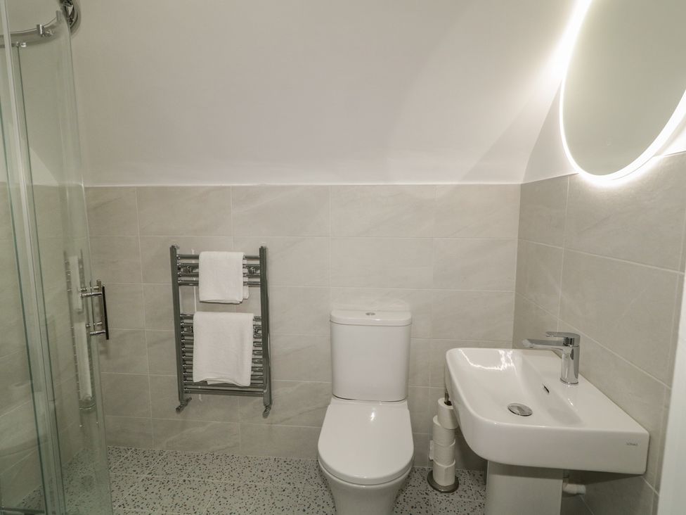 A bathroom with a shower, toilet, and sink at 30 River Run, Belturbet, County Cavan