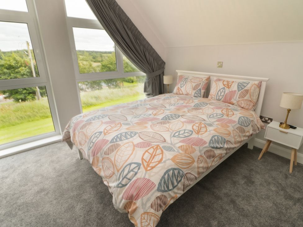 A bedroom with a bed and windows at 30 River Run, Belturbet, County Cavan