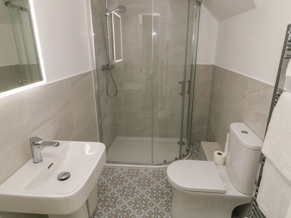A bathroom with a shower, sink, and toilet at 30 River Run, Belturbet, County Cavan