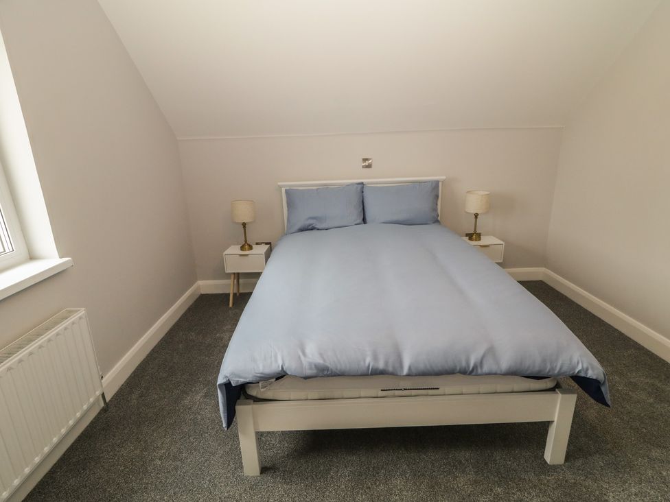 A bedroom with a bed and bedside tables at 30 River Run, Belturbet, County Cavan