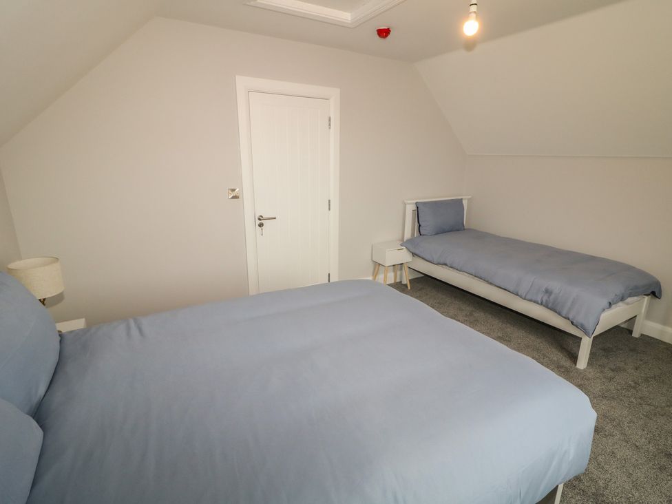 A bedroom with beds and a light fixture at 30 River Run, Belturbet, County Cavan