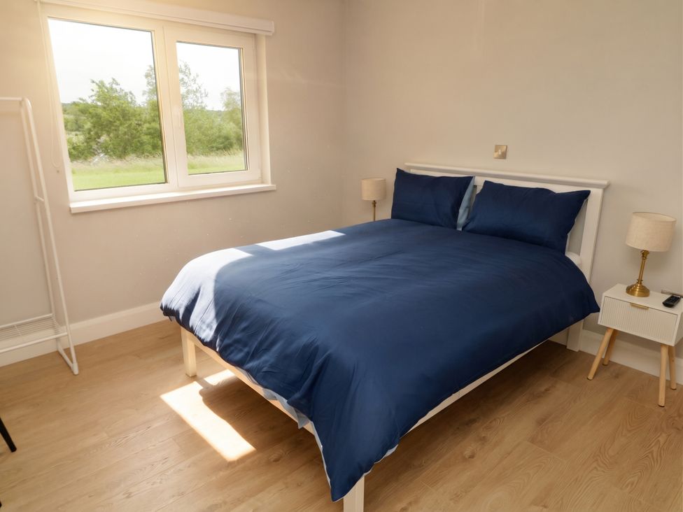 A bedroom with a bed and nightstand at 30 River Run, Belturbet, County Cavan