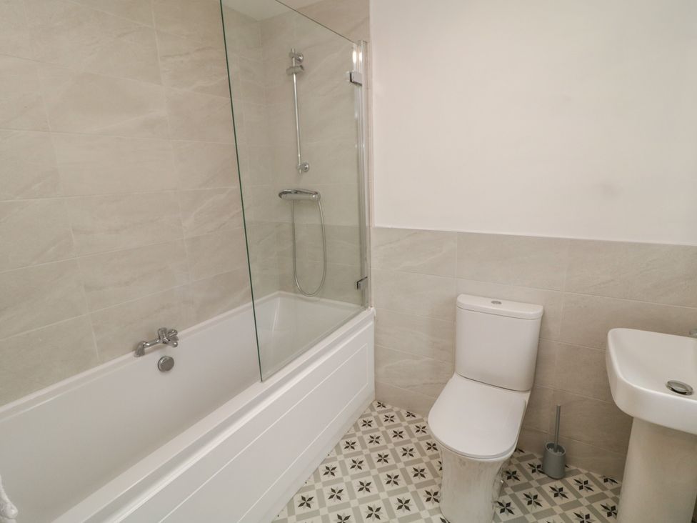 A bathroom with a bath tub, toilet, and sink at 30 River Run, Belturbet, County Cavan