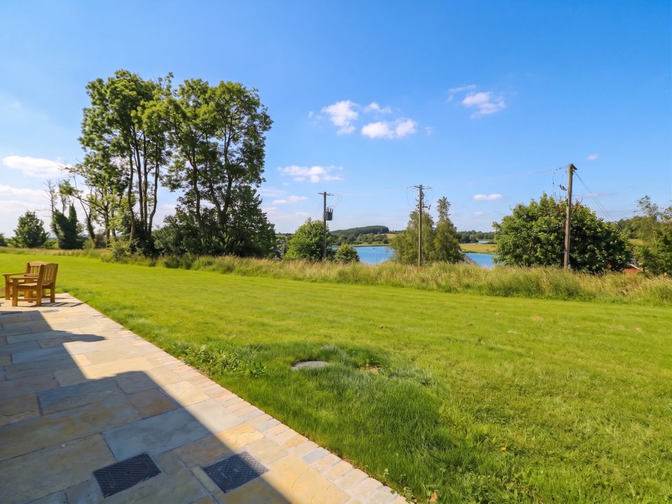 An outdoor area with a chair facing a lake at 30 River Run, Belturbet, County Cavan