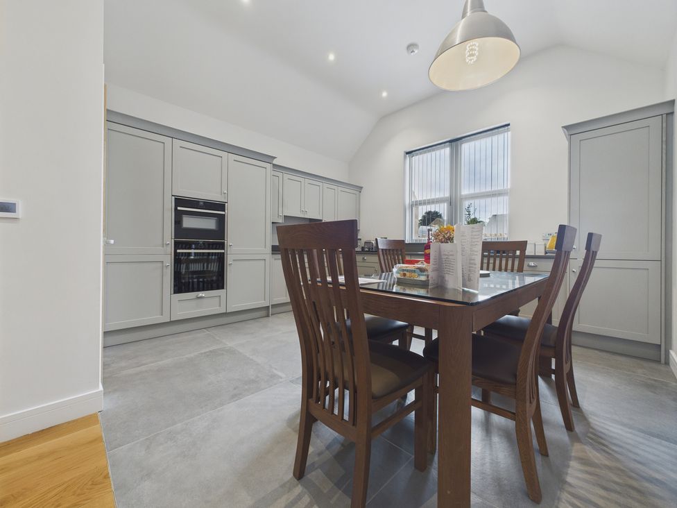A kitchen with a dining table and chairs at Oakwood Lodge in Tansley