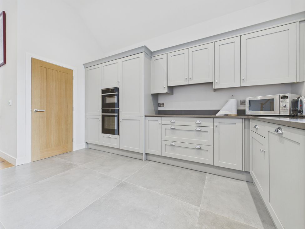 A kitchen with cabinets and appliances at Oakwood Lodge in Tansley