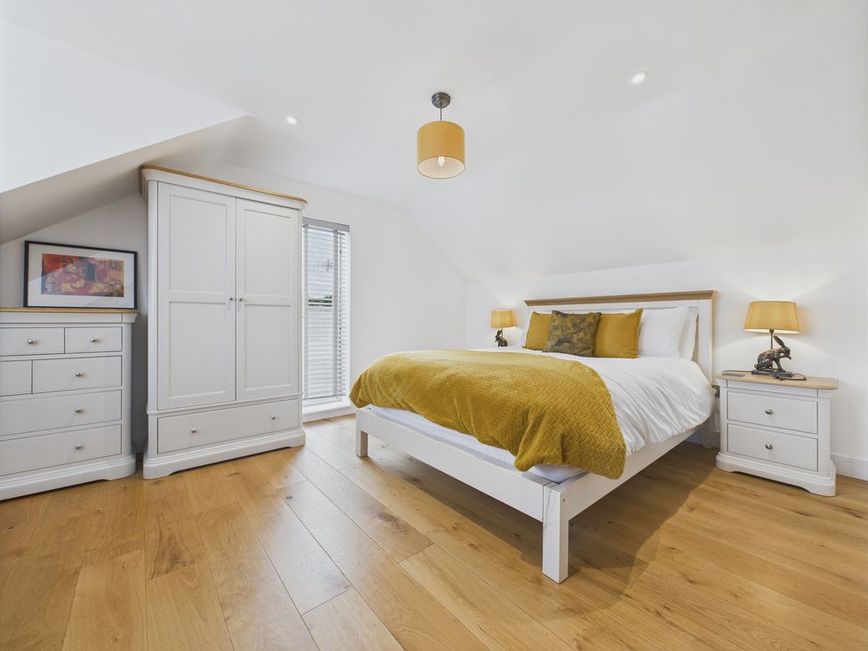 A bedroom with a bed and wardrobe at Oakwood Lodge in Tansley