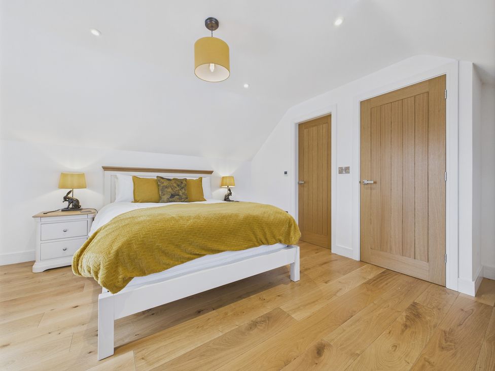 A bedroom with a bed and nightstand at Oakwood Lodge in Tansley