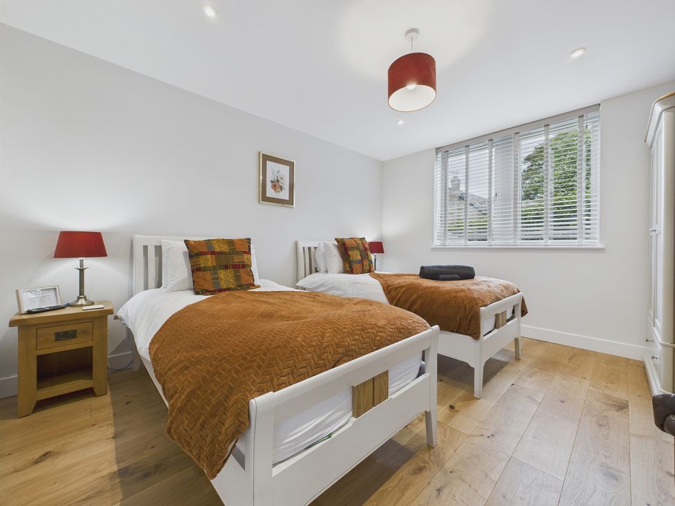 A bedroom with two beds and a window at Oakwood Lodge in Tansley