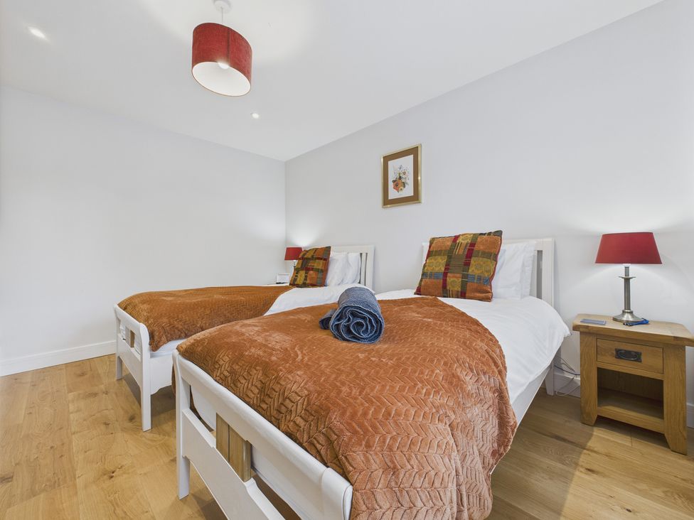 A bedroom with two beds and a side table at Oakwood Lodge in Tansley