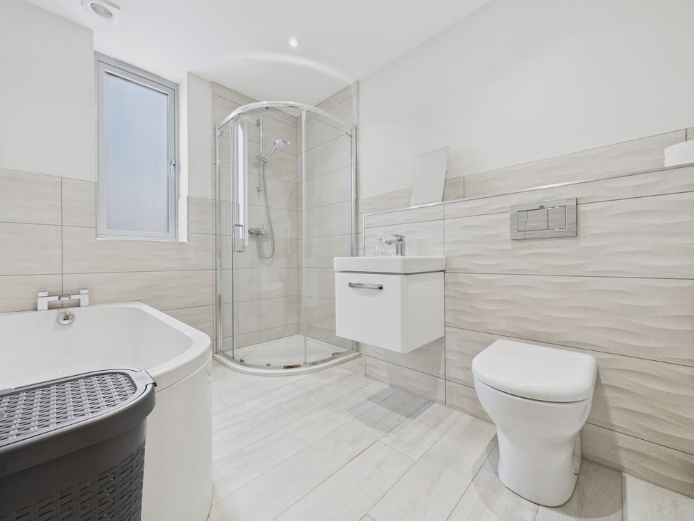 A bathroom with a shower, bathtub, toilet, and sink at Oakwood Lodge in Tansley