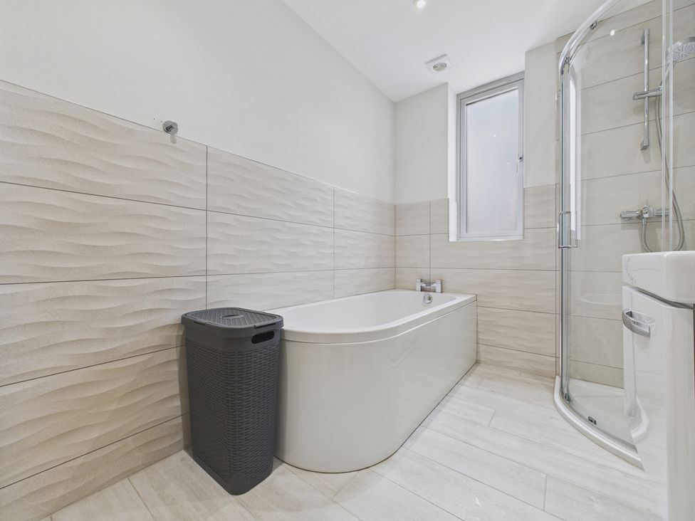 A bathroom with a bathtub and shower at Oakwood Lodge in Tansley