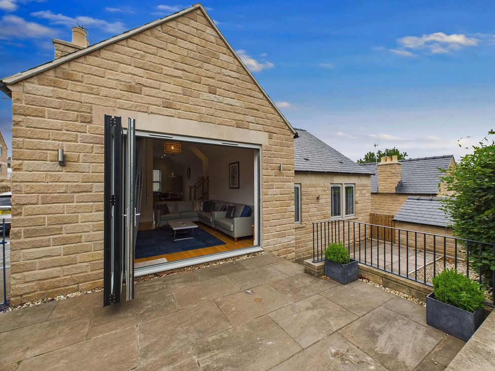 An outdoor patio with a sliding door leading to a living room at Oakwood Lodge in Tansley