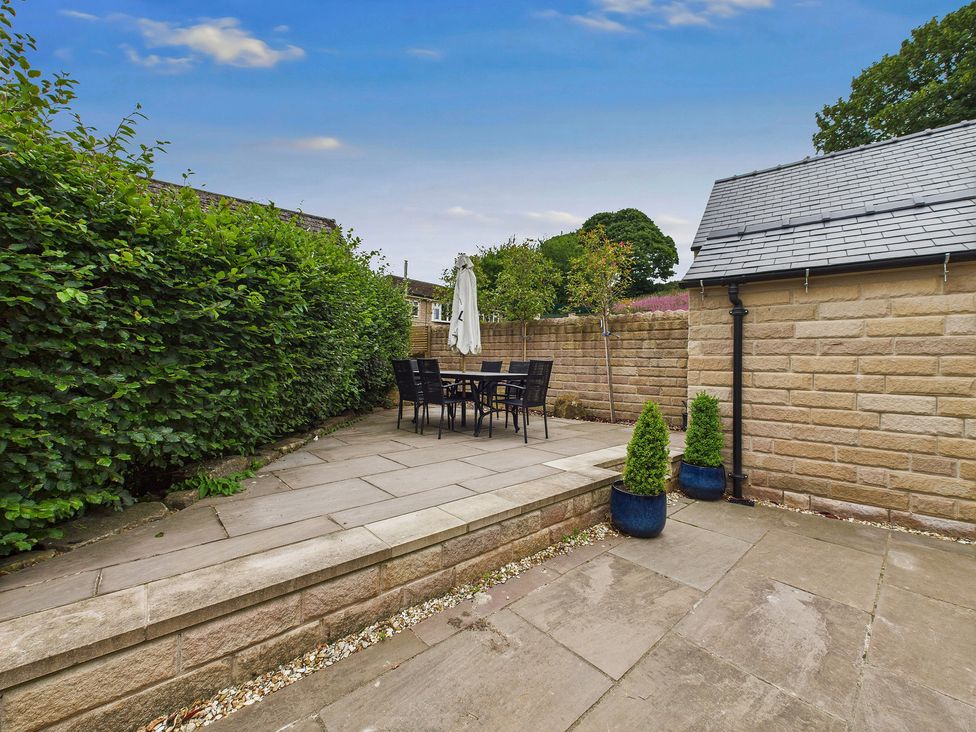 A garden with a dining set and plants at Oakwood Lodge in Tansley