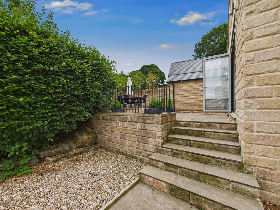 A garden with steps leading to a patio area at Oakwood Lodge in Tansley