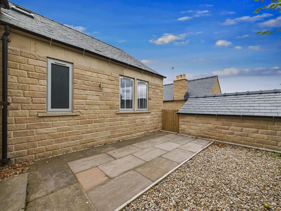 An outdoor area with a stone wall and gravel at Oakwood Lodge in Tansley