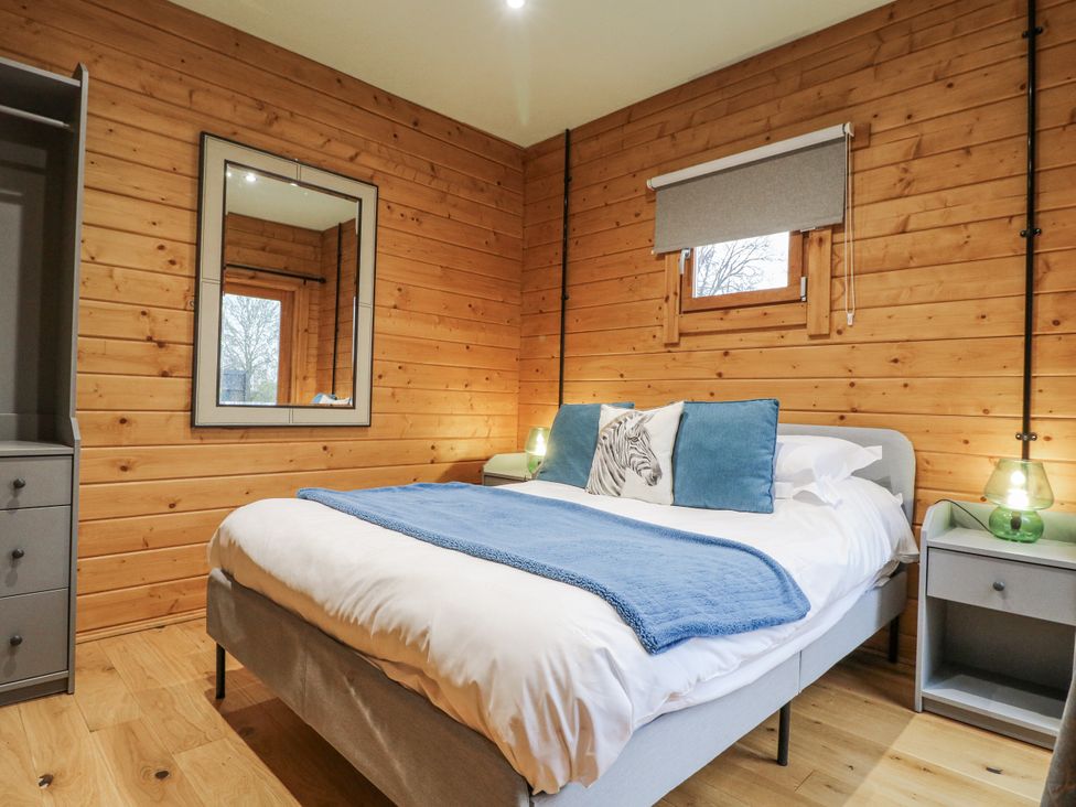 A bedroom with a bed and nightstand at Otter's View in South Luffenham near Edith Weston