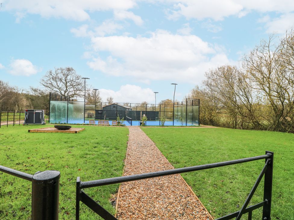 An outdoor area with a pathway and tennis court at Otter's View South Luffenham near Edith Weston
